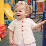 Μωρό που φορά την πλεκτή ζακέτα EVELIN σε παιδική χαρά