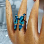 Macrame δαχτυλίδι πεταλούδα σε ξύλινο display χεριού