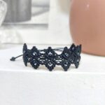 Μαύρο macrame βραχιόλι με γεωμετρικό μοτίβο και μαύρα κρύσταλλα σε ουδέτερο φόντο