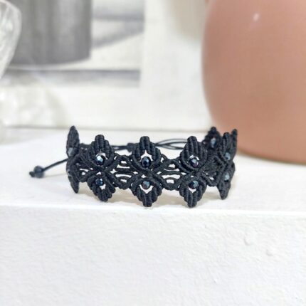 Μαύρο macrame βραχιόλι με γεωμετρικό μοτίβο και μαύρα κρύσταλλα σε ουδέτερο φόντο