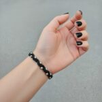 μαύρο macrame βραχιόλι φορεμένο σε γυναικείο καρπό