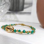Λεπτομέρεια πλέξης macrame με πετρόλ χάντρες και χρυσά στοιχεία