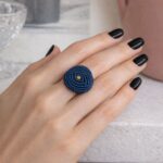 Macrame μπλε δαχτυλίδι Indigo με διακριτική χρυσή λεπτομέρεια φορεμένο σε γυναικείο χέρι
