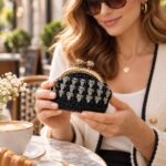 Μαύρο πλεκτό πορτοφολάκι για κέρματα AIKATERINA κρατημένο στο χέρι σε café