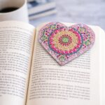 χειροποίητος σελιδοδείκτης mandala καρδιά πάνω σε ανοιχτό βιβλίο