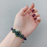 Macrame βραχιόλι MAYA DARK φορεμένο με κρυστάλλινο λουλούδι σε μωβ αποχρώσεις